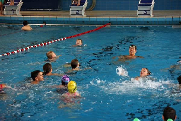 Damian Wierling schwimmt mit Kindern im Wasser